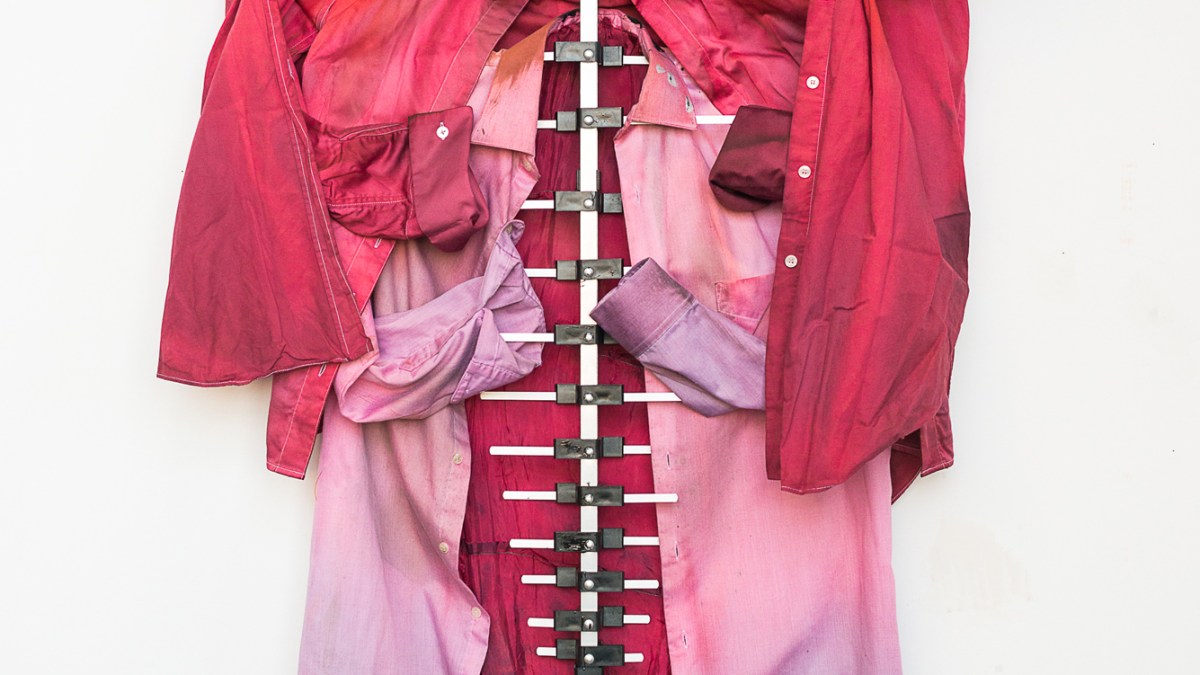 Tahir Karmali, Pull me apart and I'll show grace, 2024, second-hand cotton shirts, fabric dye, oxidized iron dye from guns, plastic, aluminum, safety pin, and liquid rubber, 35.5 x 52 x 4.5 inches.
